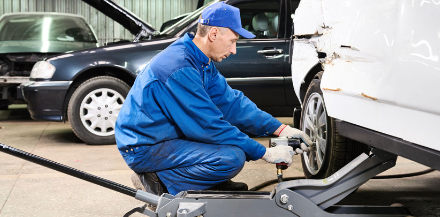 Mechanic changing tire for NYS inspection